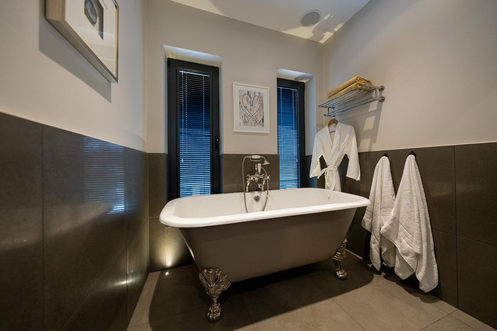 Bathroom with a roll-top bath and towels